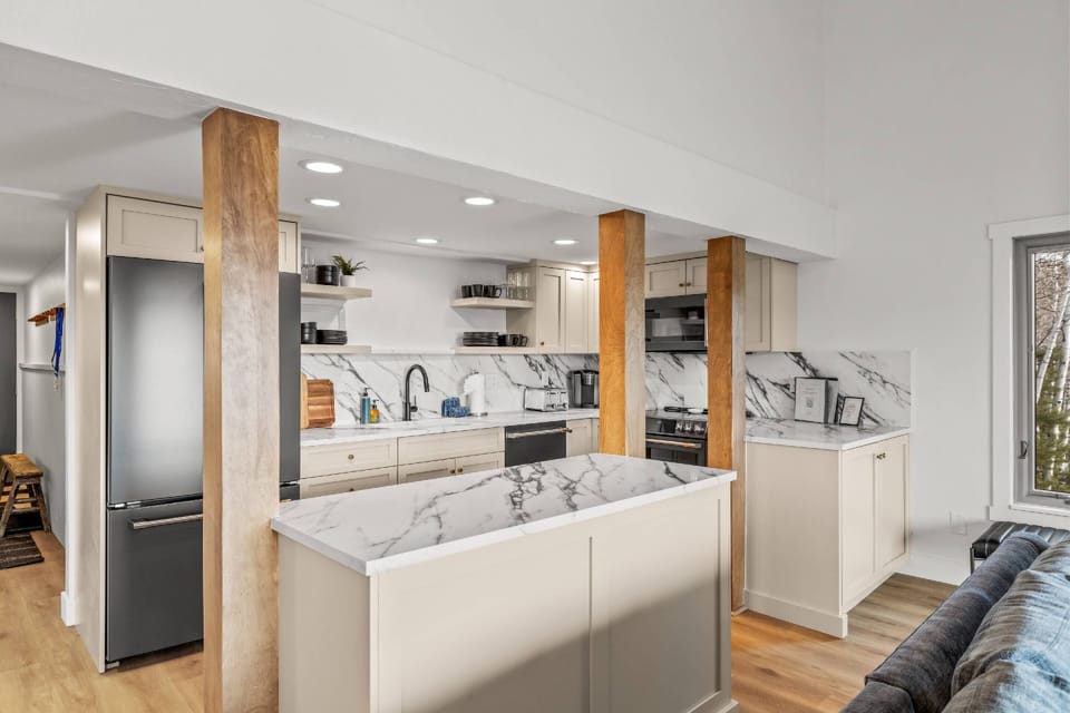 Bright modern kitchen with marble counters and warm wood accents