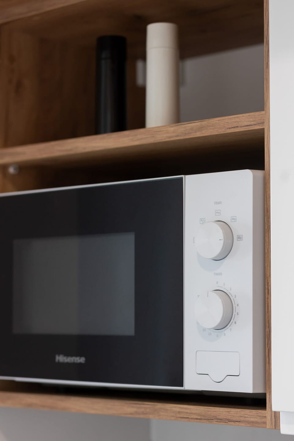 A built-in microwave and open shelving, combining practicality and style in the kitchen.
