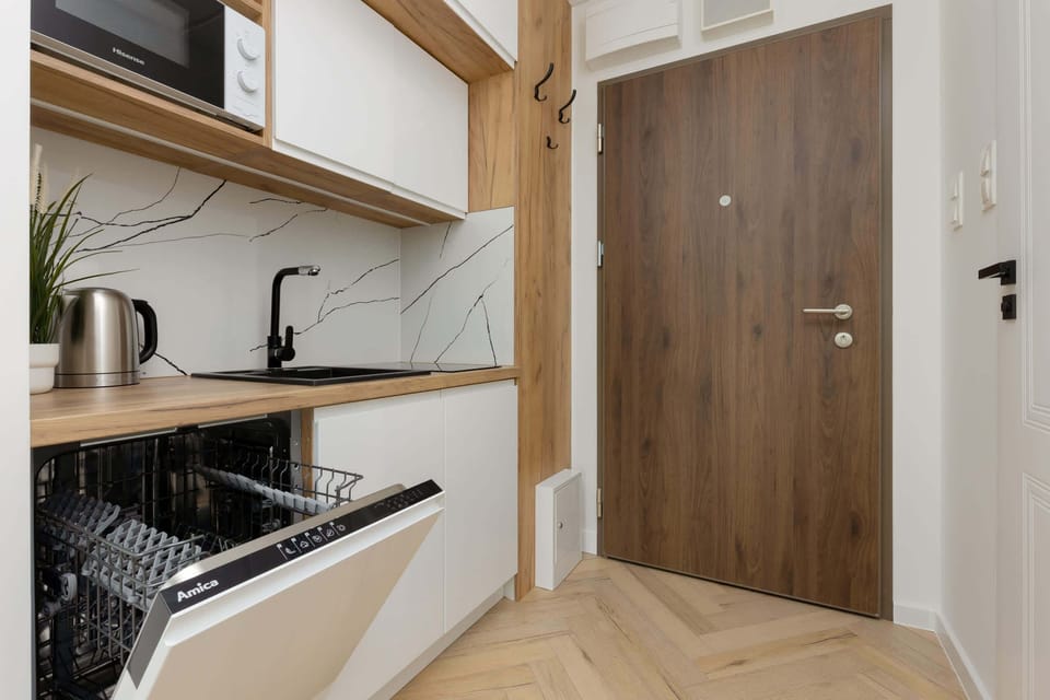A view of the kitchen and entryway with modern wooden finishes and a welcoming ambiance.





