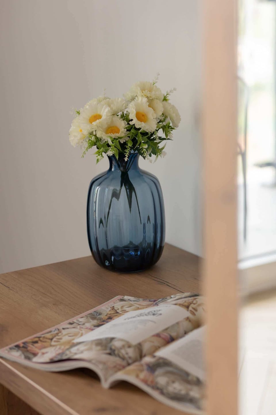 A small table topped with a decorative vase and flowers.