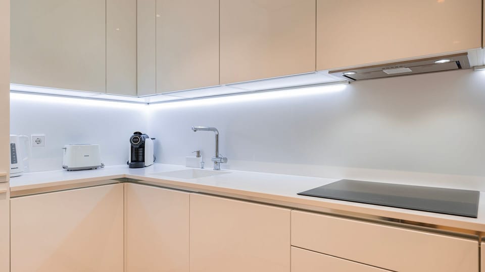Prepare a delicious breakfast or a quick snack in this sleek, fully equipped kitchen, complete with modern appliances like an espresso machine and toaster for your convenience.