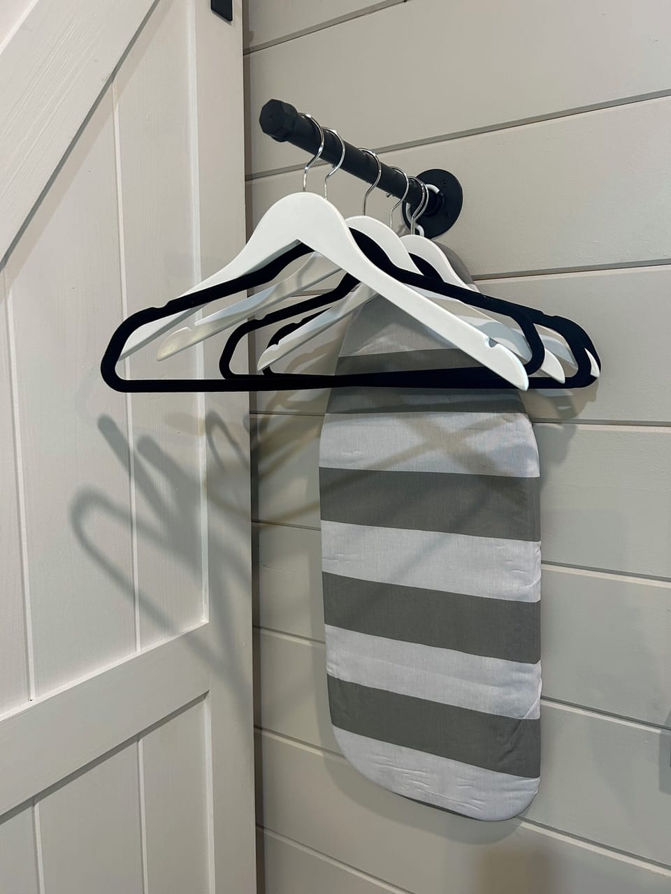 Ironing Board & Clothes Hanging Area in stylish tiny home with fenced yard.