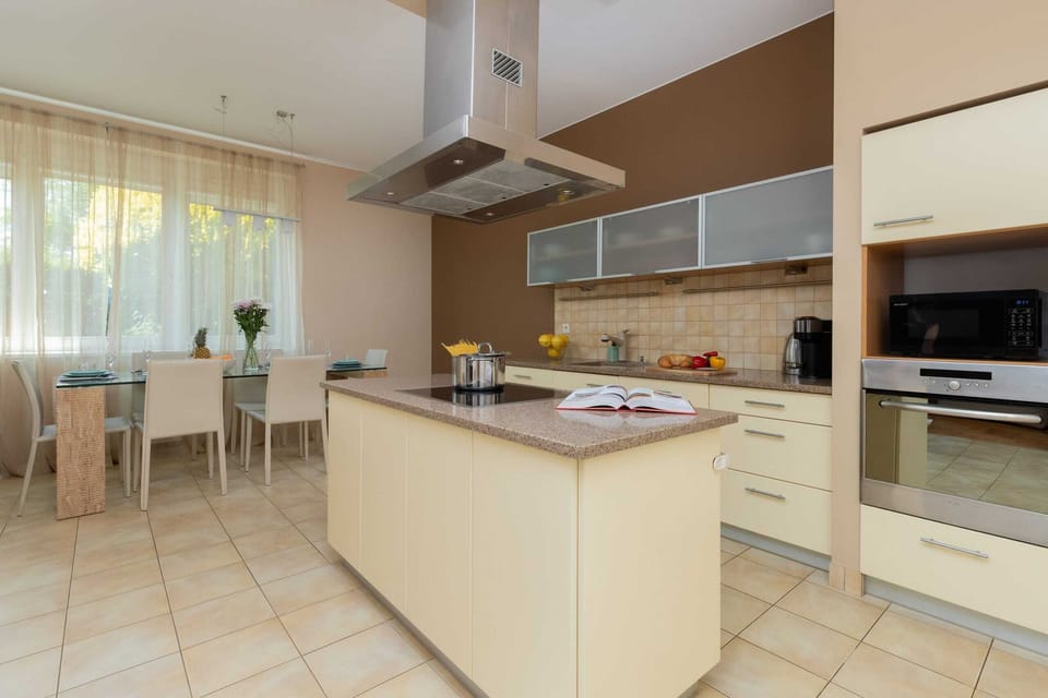 A spacious kitchen with a modern island, sleek cabinetry, and a dining area with natural light.
