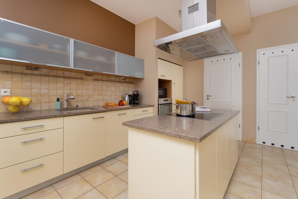 Another view of the kitchen highlighting its open-plan layout and bright tiled walls.
