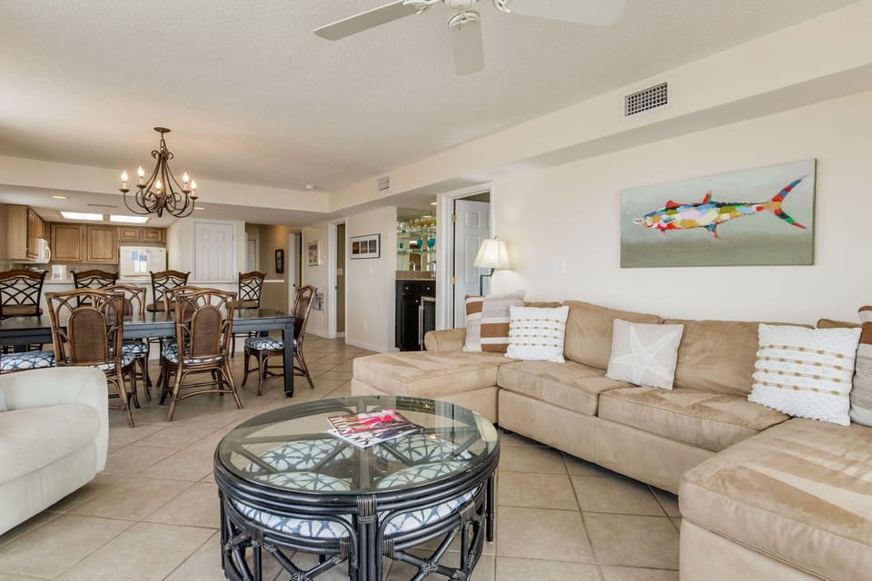 Living room with large sectional sofa and floor-to-ceiling windows at Wind Drift Orange Beach Gulf-front vacation rental