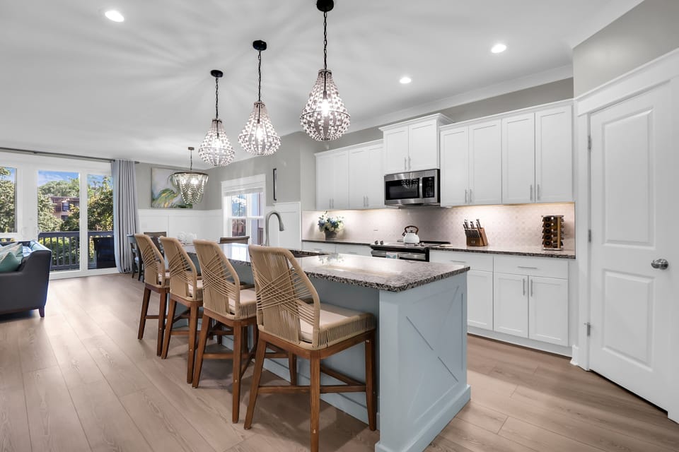 Gorgeous kitchen remodeled with new appliances, upgraded shell & stone backsplash, under cabinet lighting, and new pedants over an extra large custom island painted in a beautiful coastal accent color.