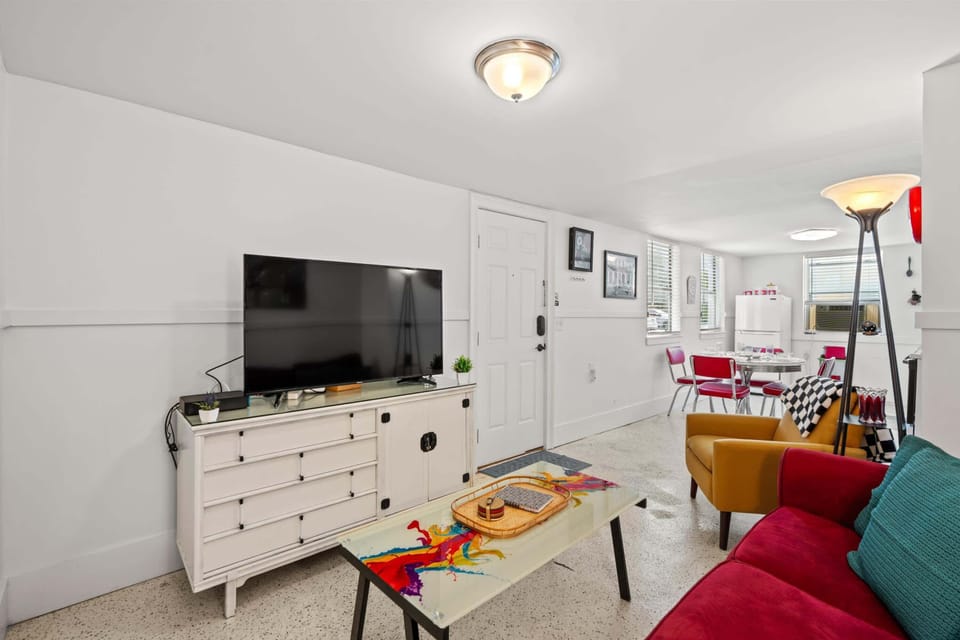 A sitting area with a comfy sofa that faces a large TV, providing a relaxing space to hang out