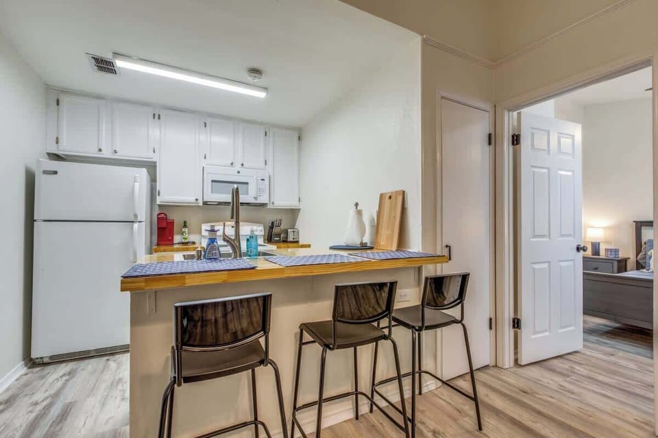 Cozy kitchen and dining area with a convenient breakfast bar and seating for three—perfect for casual meals and gathering together.