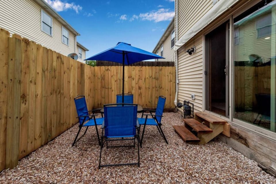 Private Rear Patio, accessible from Living Room with table, chairs, and umbrella