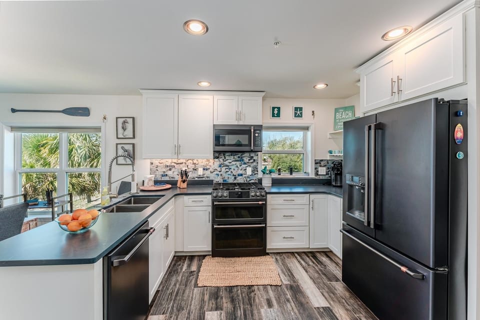 Open gourmet kitchen is stocked w/ spices, oils, utensils and small appliances.