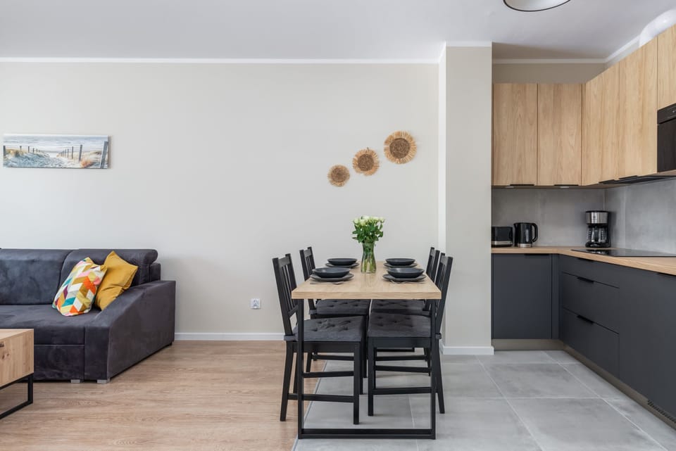 A sleek dining area connected to the kitchen, featuring a black dining table and modern decor.