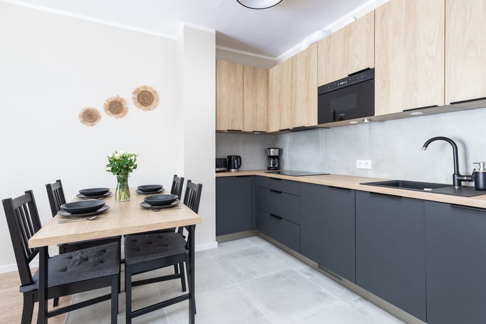 A sleek dining area connected to the kitchen, featuring a black dining table and modern decor.