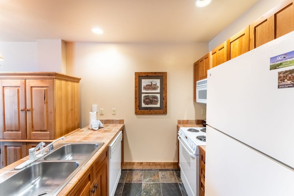 Your fully equipped kitchen features warm wood cabinets, full-size appliances, and ample counter space for preparing meals during your stay.