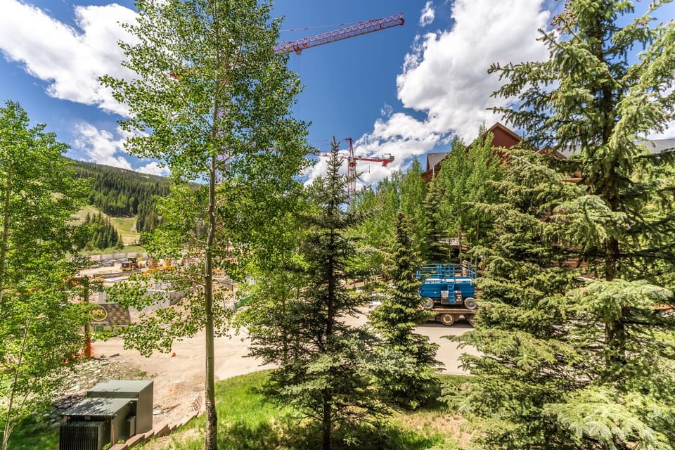 Construction activity visible in this mountain resort area with cranes and development work in progress among the trees.