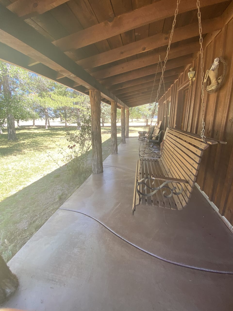 sitting on the front porch with hanging swing and rocking furniture. Its a dream