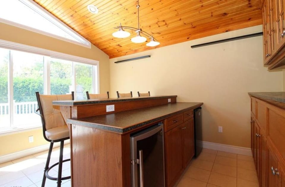 Bar of 4 seats at main floor. with fridge. Look through large window to backyard