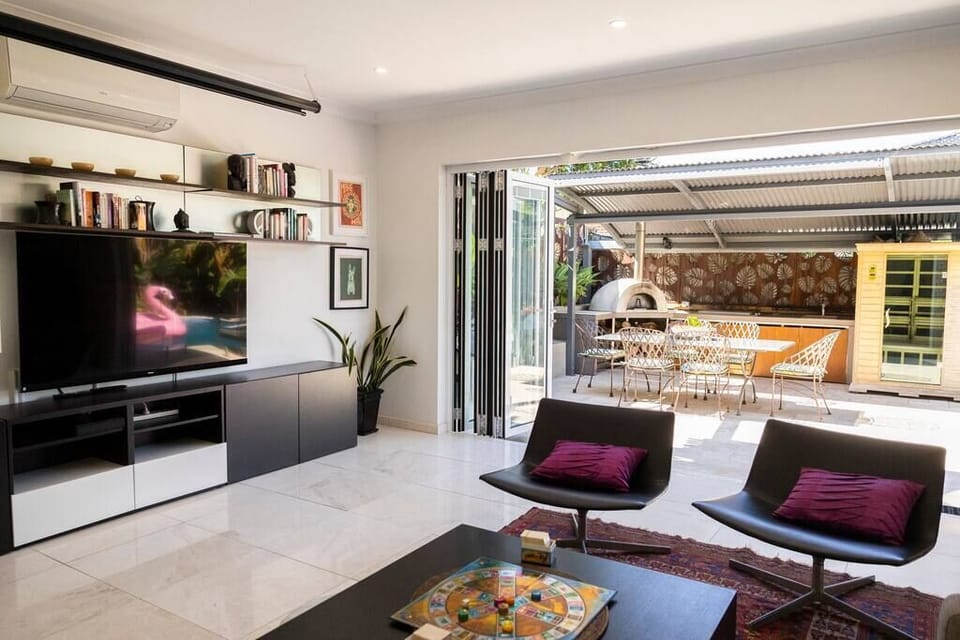 Lounge room opens to entertaining area with BBQ, outdoor setting and pool