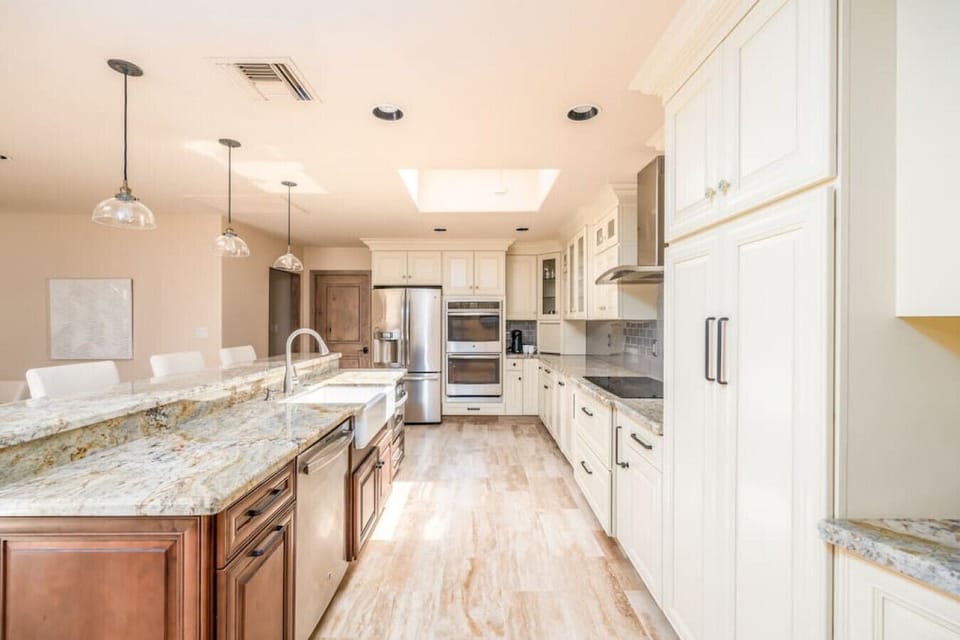 Light-filled chef’s kitchen featuring granite counters, double ovens, and ample prep space.