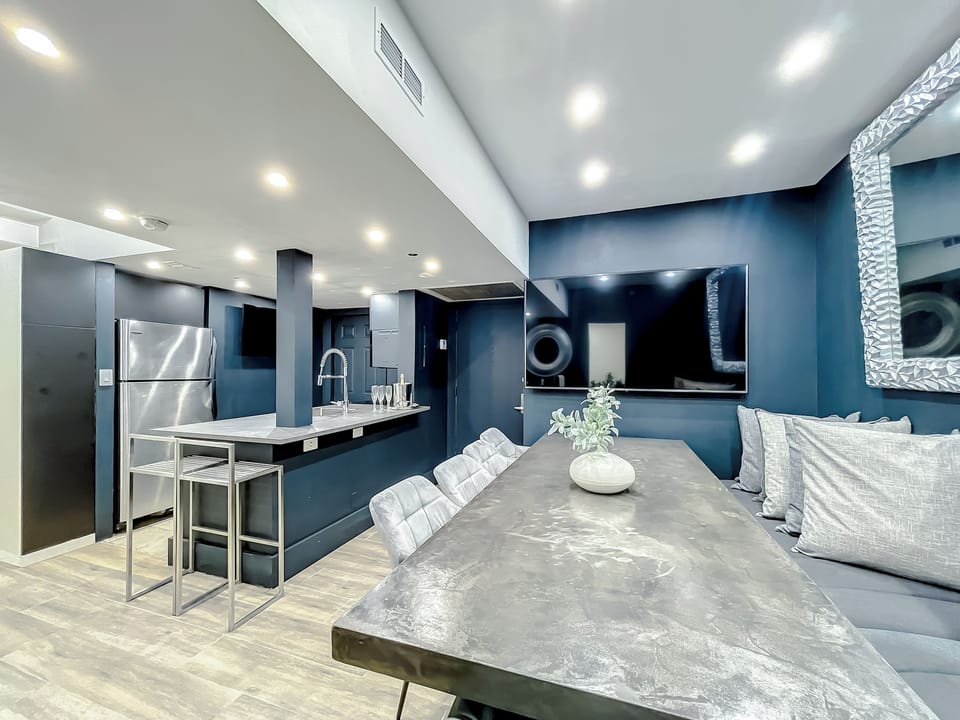 Full-size kitchen with brand new state-of-art Samsung stove, convection oven, air fryer, island bar with in-kitchen dining, entertaining 70-inch smart TV in the dining room, 50-inch in kitchen, stone dining table for up to 12 persons & bar seating.