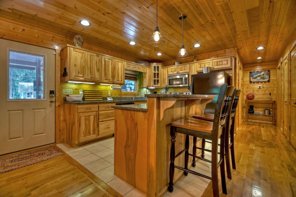 Kitchen island with bar seating and forest views from window 