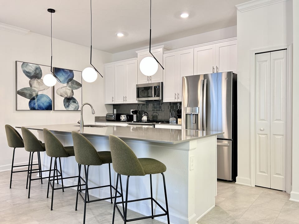 Fully equipped modern-style kitchen with a spacious island and seating stools