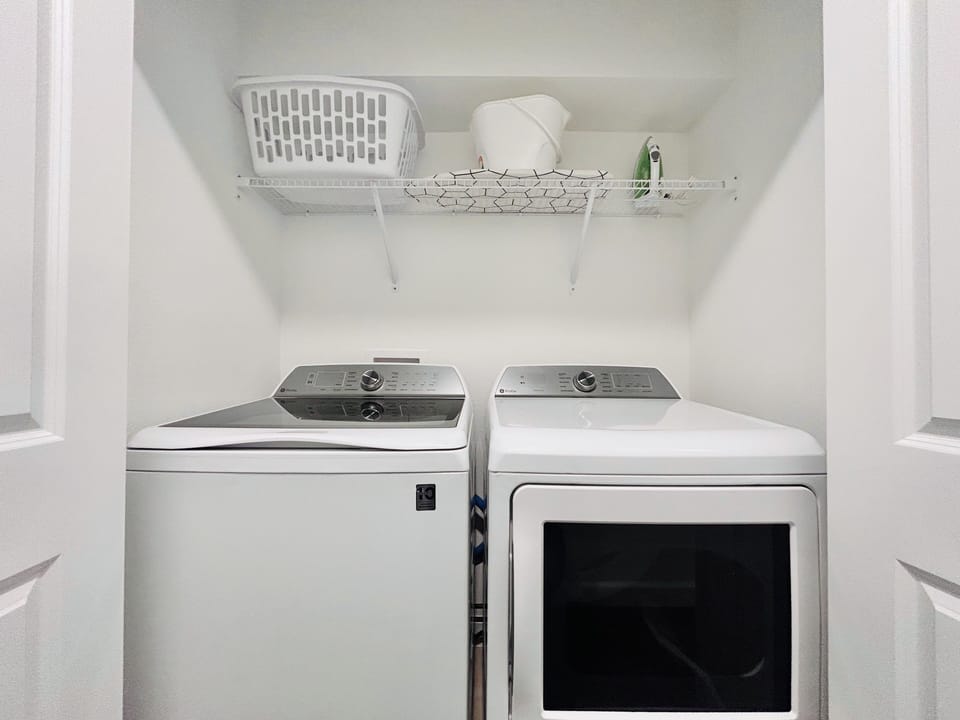 Fully-equipped laundry room with modern appliances, ironing facilities
