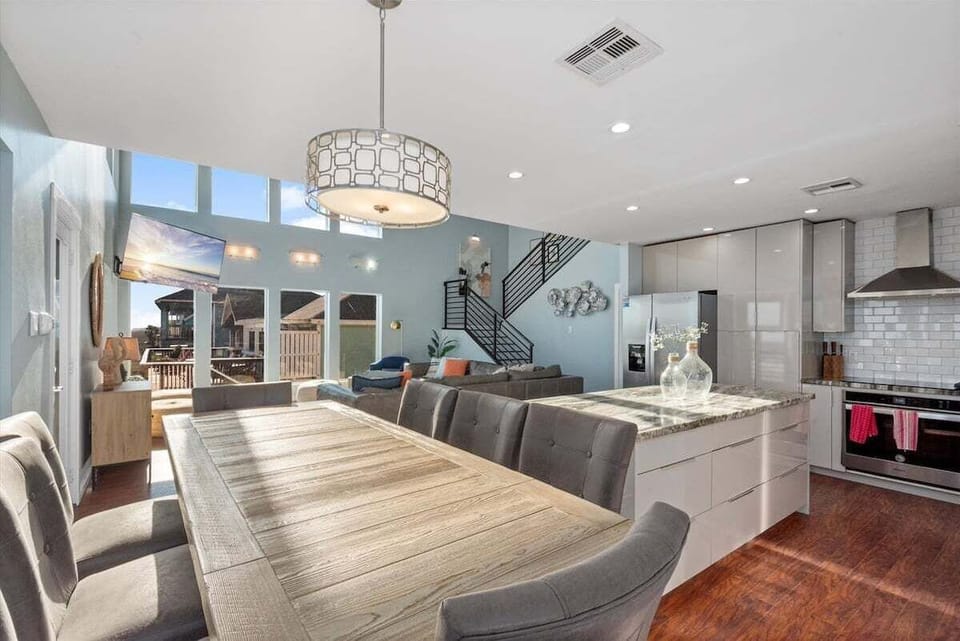 Dining area with large table, statement chandelier, and open-concept layout