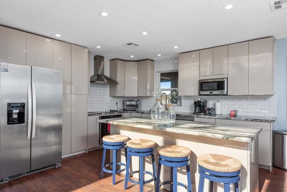 Modern kitchen featuring stainless steel refrigerator, oven, and ample cabinet storage