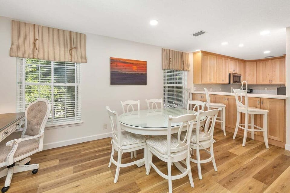 Dining area with white table and view to kitchen