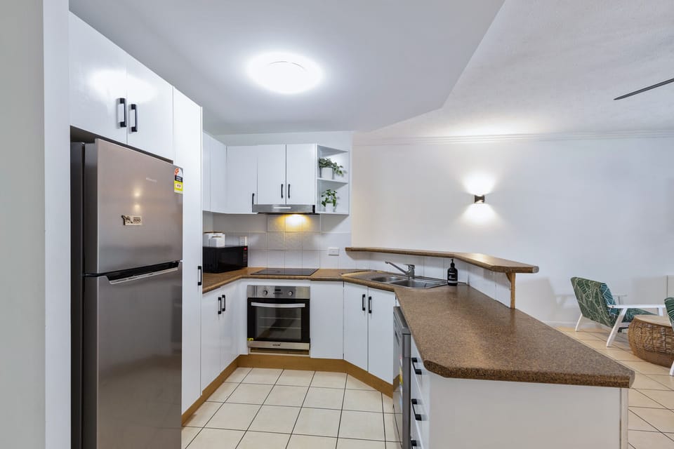 Kitchen with fridge, microwave, toaster, kettle and oven. 