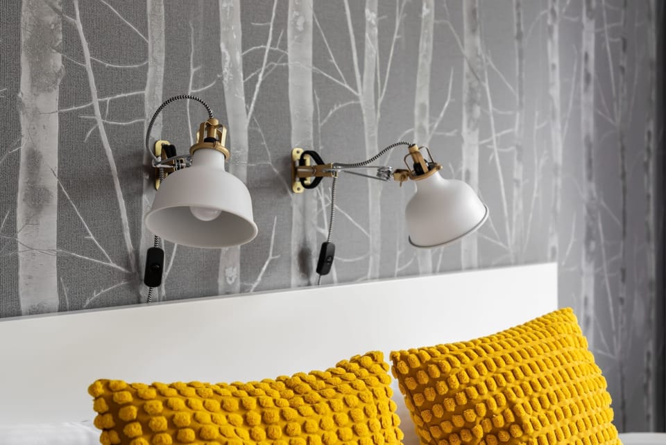 A close-up of the bed's headboard with modern bedside lamps, adding to the elegant atmosphere.






