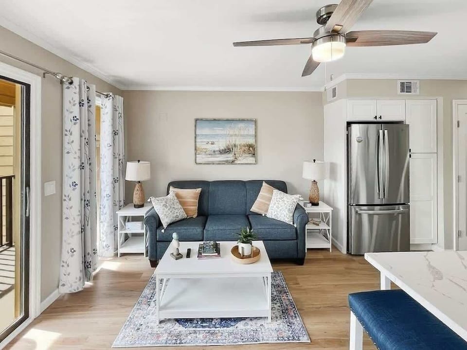 A bright, open-concept living space featuring a comfortable blue sofa.