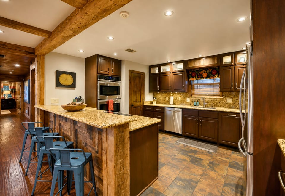 The spacious kitchen offers plenty of room to cook and gather, with generous counter space, bar seating, and warm wood finishes that fit right into the cabin atmosphere.