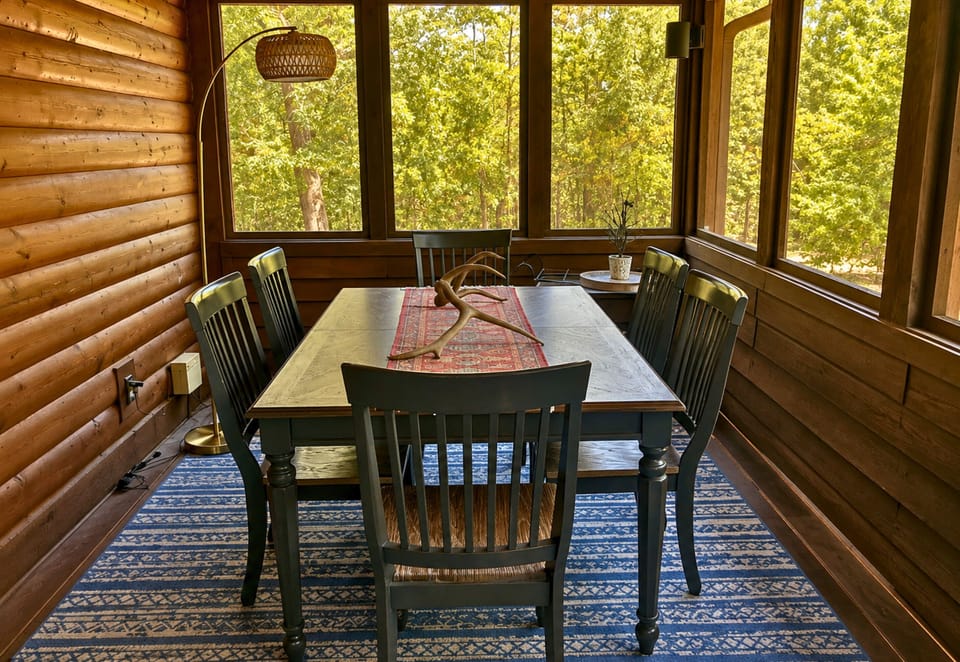 Another dining area in the screened-in porch gives the group even more room to gather, with plenty of seating and wooded views just beyond the screened surroundings.