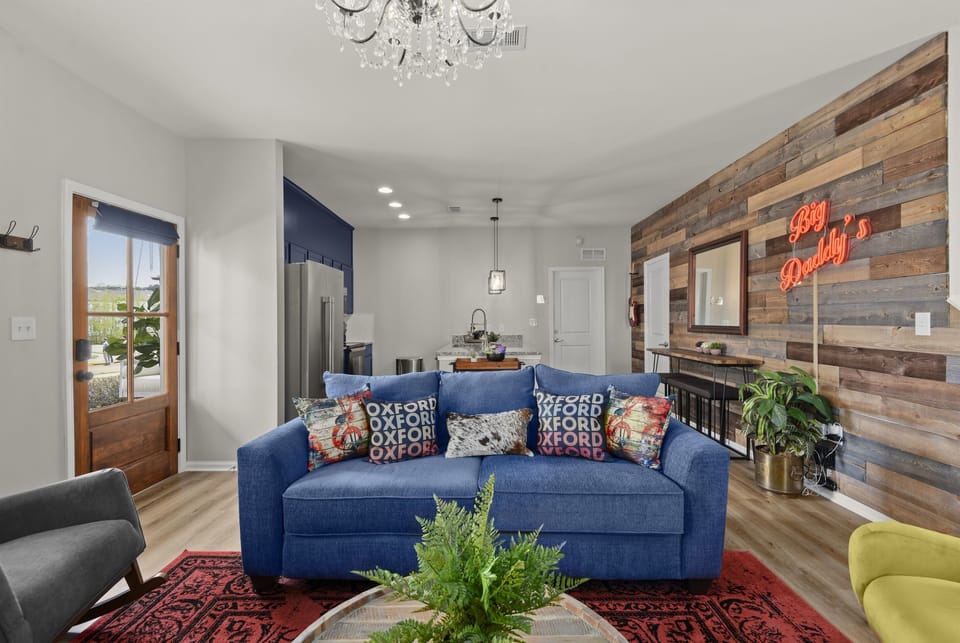 The hand crafted and stained pine door lead into the authentic living area with touches of natural wood, colorful plants and deep red Big Daddy’s sign.