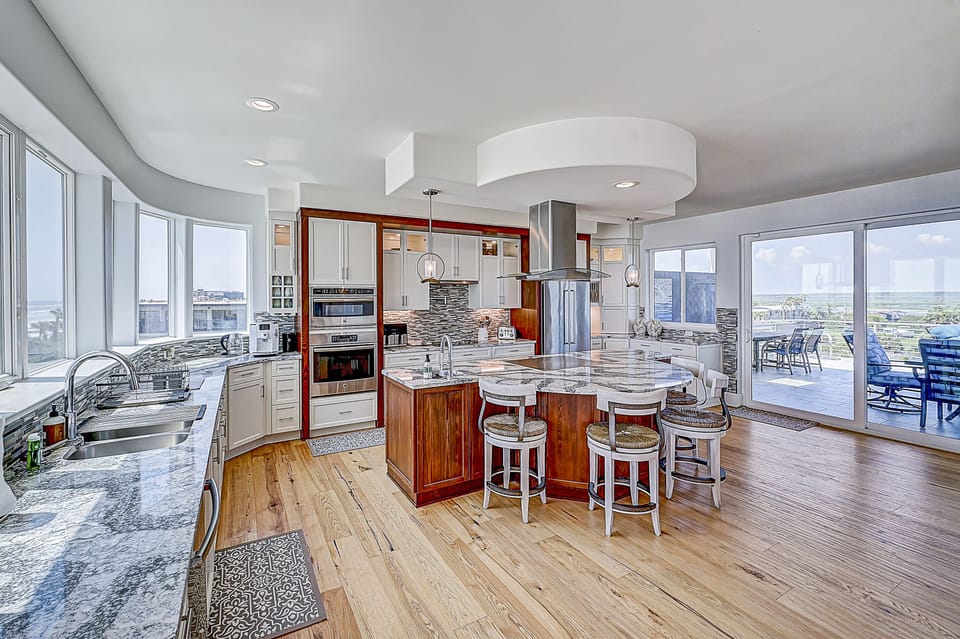 Open-plan kitchen with modern appliances and ocean view.