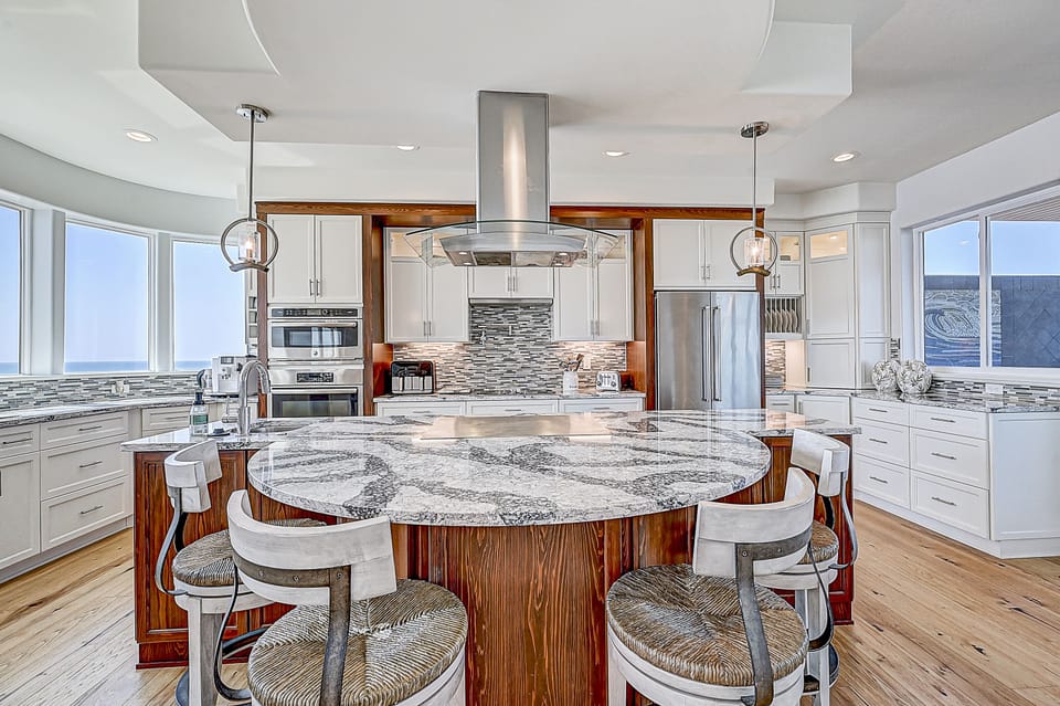 Modern kitchen with a large island and stainless steel appliances.