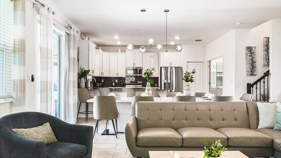 Spacious open living area with modern kitchen, comfy seating, bright and stylish
