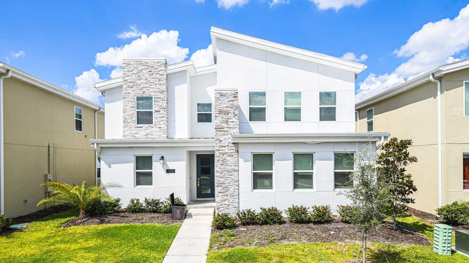 Modern spacious villa with bright exterior, stylish stone accents and welcoming entry
