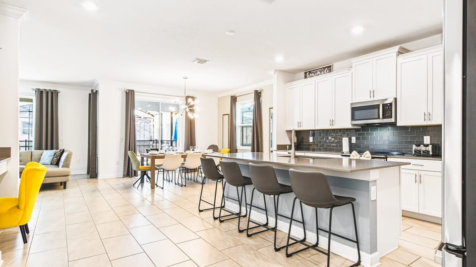 Spacious chef’s kitchen with large island, sleek finishes, and seating for six