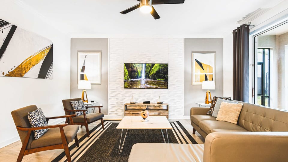 Cozy modern living room with smart TV, sleek decor, and natural light views