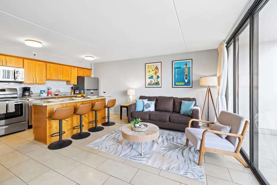 The living room features a pull-out sleeper sofa, coffee table, chair, and a window AC