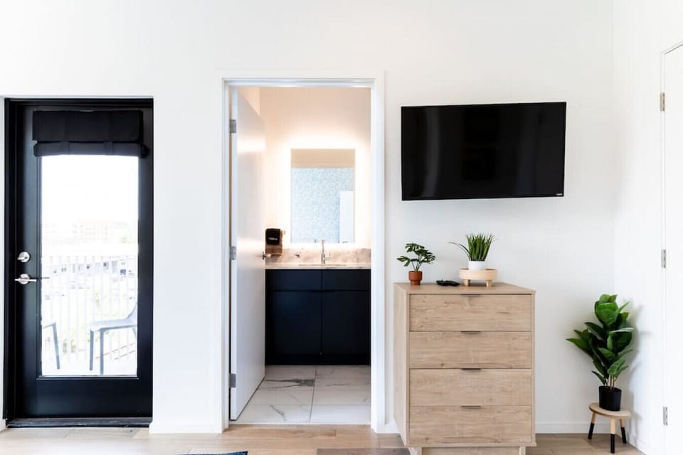 Comfortable King bed in bedroom #1 with a Smart TV, private ensuite bath, and door to the second private patio.