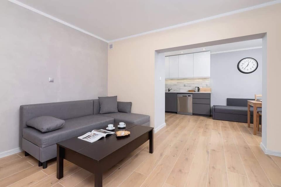 Another perspective of the living room, featuring a comfortable sofa and a dining area in the background.

