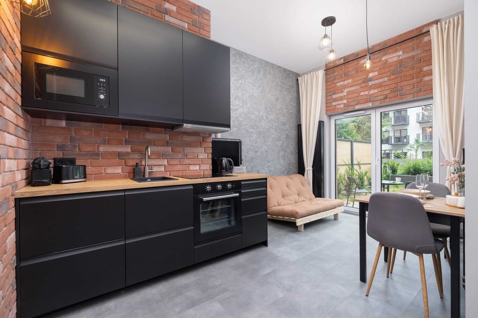 A bright dining and living space, with a large window and access to the garden terrace.


