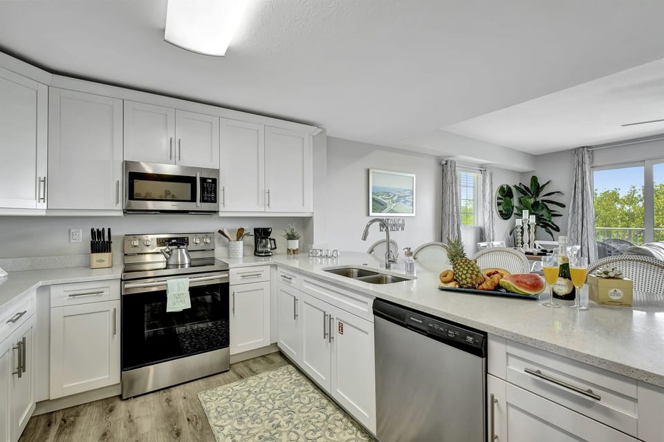 The kitchen, a space that transcends mere functionality, welcomes you with its pristine elegance and modern charm.