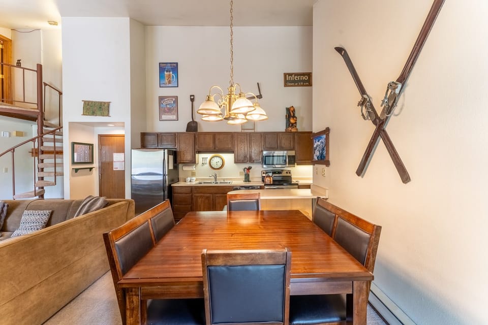 Gather around your warm wooden dining table under charming pendant lights, with the full kitchen just steps away for effortless meal prep.