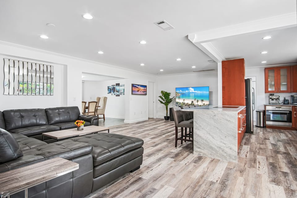 Living room features a large leather sofa and sleek flat screen TV