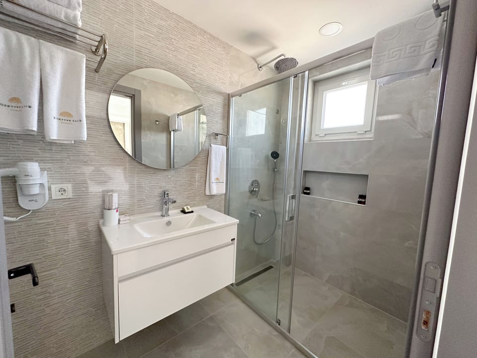 Deluxe Room | Bathroom | Rainfall showerhead, free toiletries, hair dryer, slippers