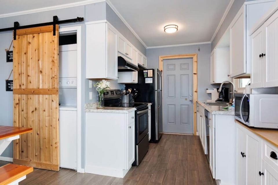 This sleek kitchen has serious style with that sliding barn door doing the heavy lifting between spaces.